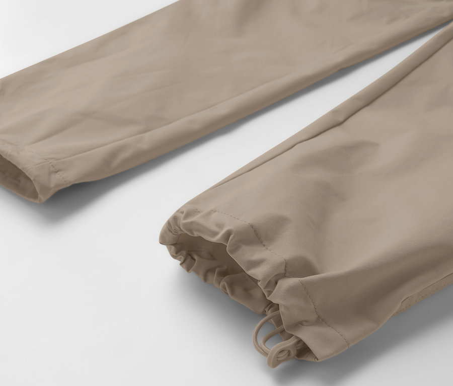 Szczegół beżowych spodni funkcyjnych 2 w 1.