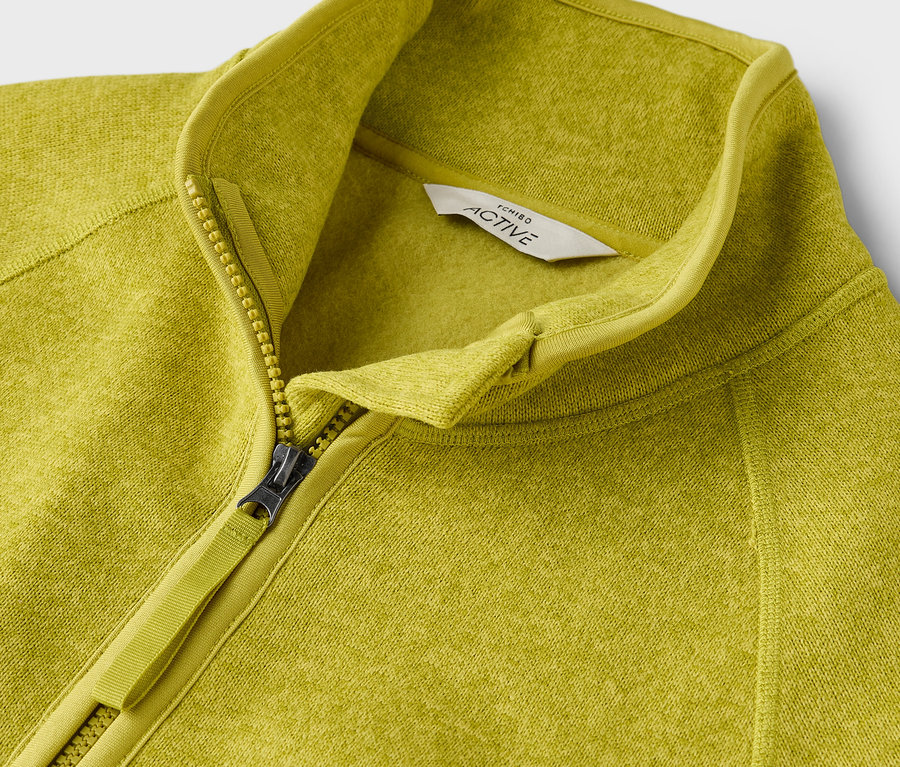Zbliżenie na żółto-zieloną bluzę polarową Active zapinaną na zamek.