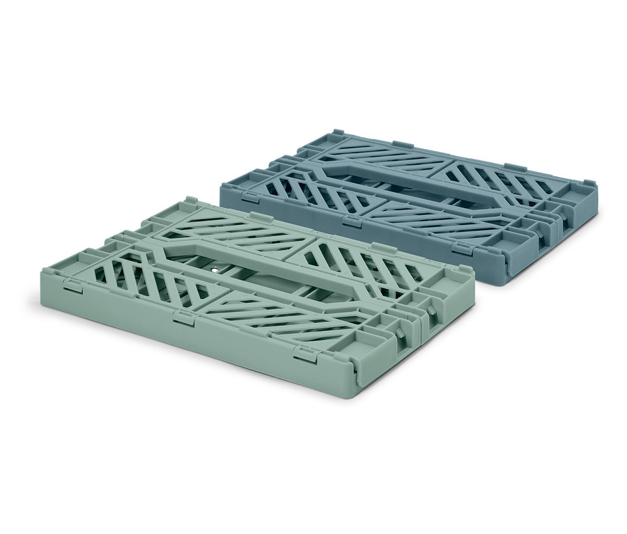 Dwa składane pojemniki do przechowywania, jeden jasnozielony i jeden niebieski, leżą na białym tle.