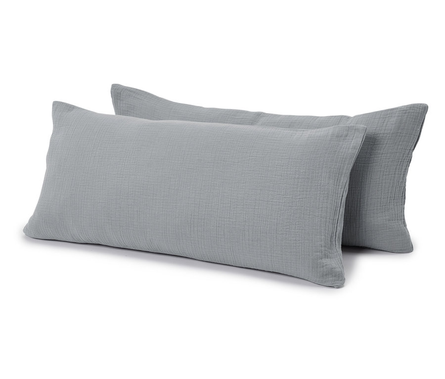 Dwie szare, prostokątne poduszki leżą obok siebie na białym tle.