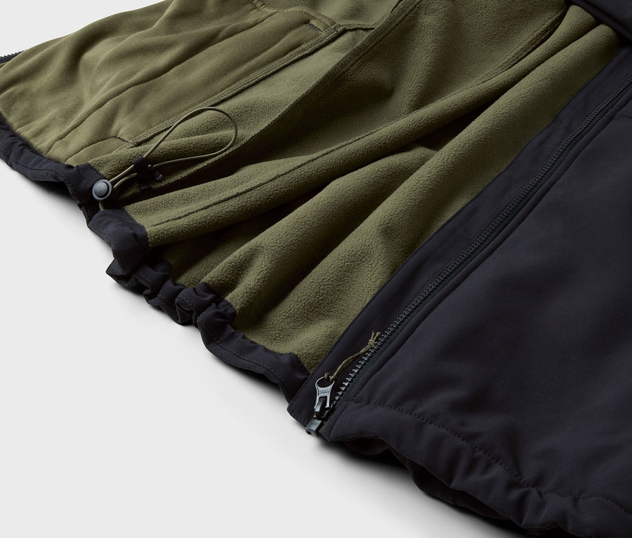Szczegół oliwkowej kurtki polarowej z czarnym obszyciem i zamkiem błyskawicznym.