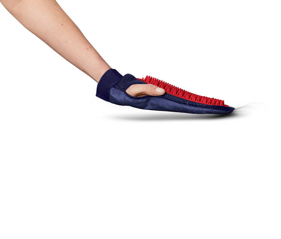 Ręka trzyma niebieską rękawicę z czerwonymi szczecinami, która zbiera sierść zwierząt.