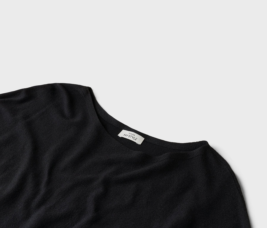 Zdjęcie z bliska czarnego t-shirtu z etykietą z napisem "TCHIBO MY STYLE".