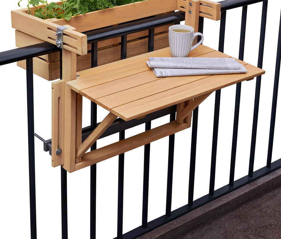 Skrzynka na rośliny z ziołami i składany stolik z gazetą i filiżanką wiszą na czarnej balustradzie balkonu.