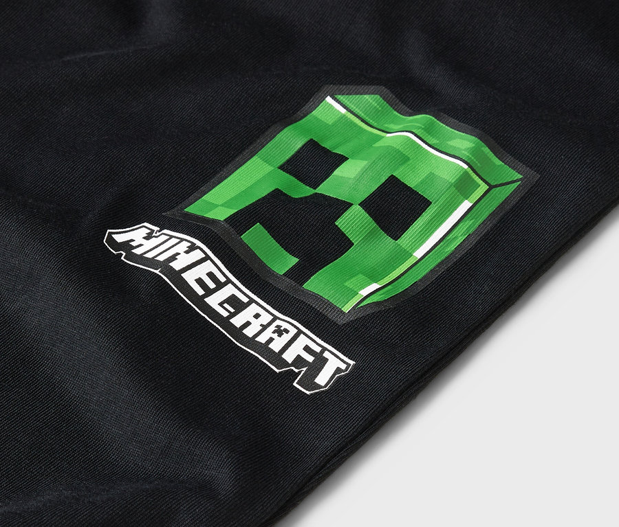Zbliżenie na czarne ubranie z zielonym wzorem Minecraft Creeper.