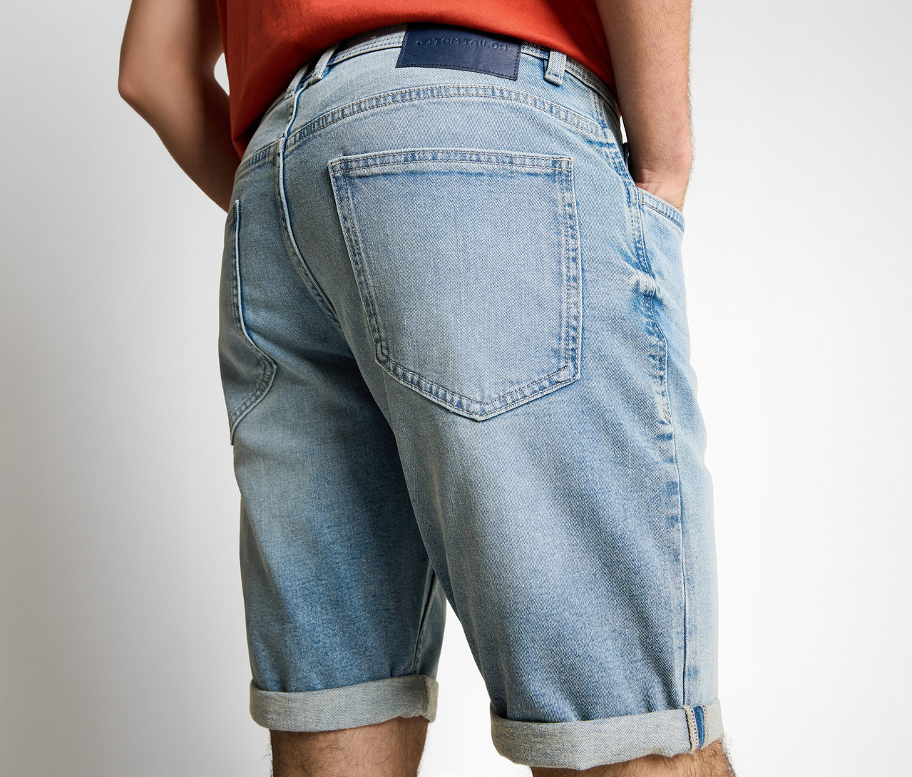 Mężczyzna od tyłu w szortach dżinsowych Tom Tailor TTJOSH REGULAR SLIM, light stone blue denim, z rękami w kieszeniach.