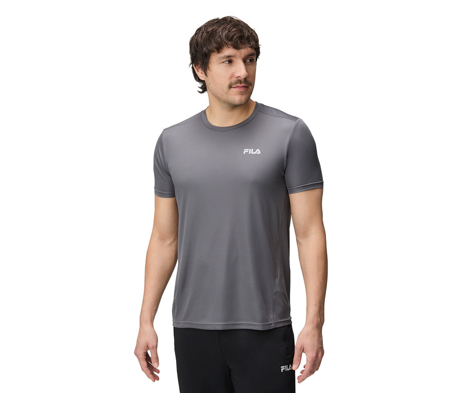 Mężczyzna ma na sobie szarą koszulkę Fila i czarne spodnie.