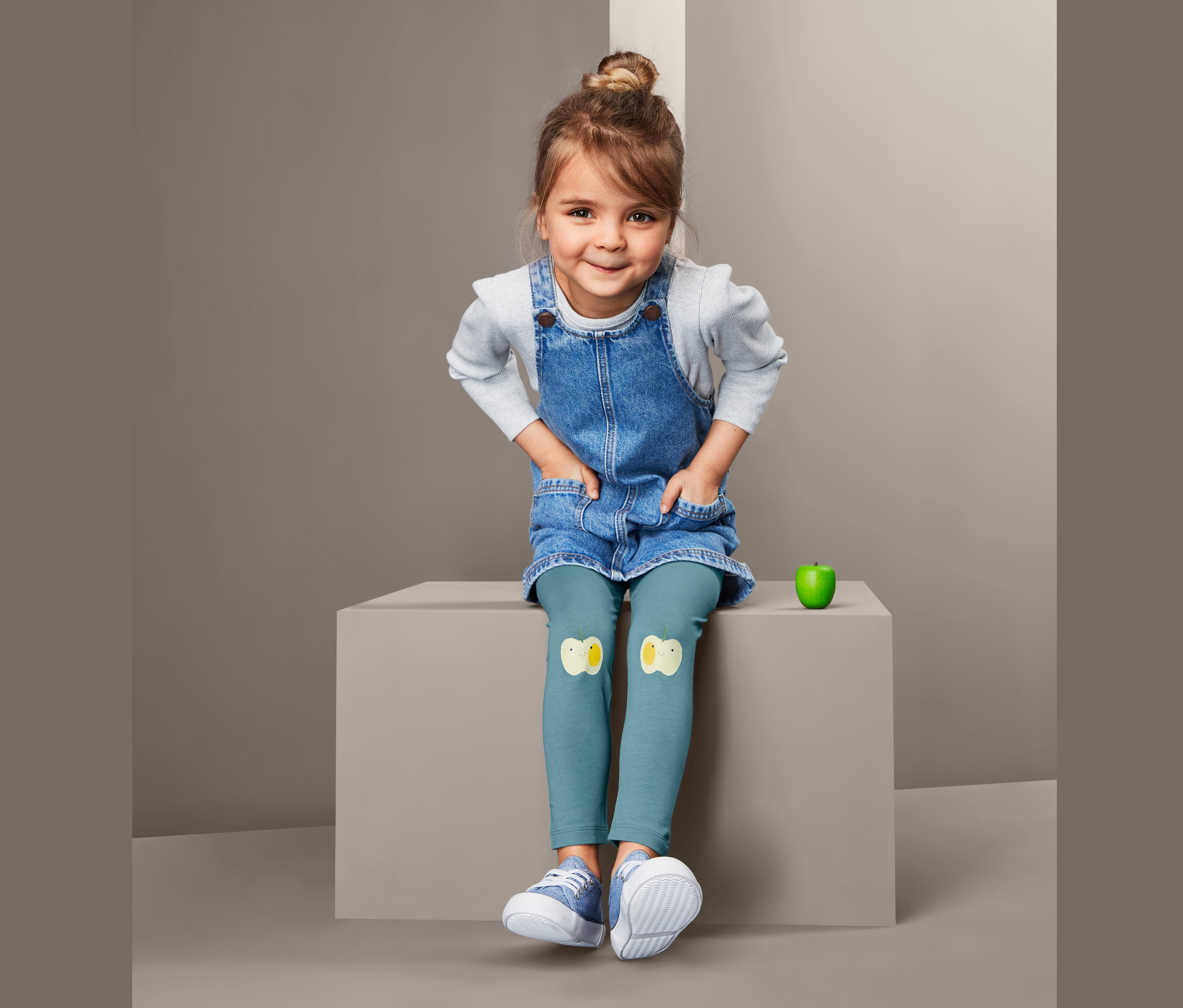 Dziewczynka siedzi w dżinsowej sukience i legginsach, 2 pary, z aplikacjami kurczaków.