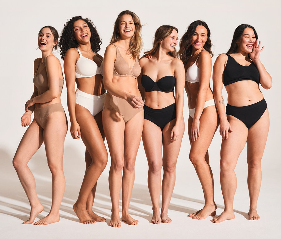 Sześć uśmiechniętych się kobiet w bieliźnie stoi obok siebie. Kobiety mają na sobie czarne i białe braletki z bawełną ekologiczną SCHIESSER, 2 sztuki.