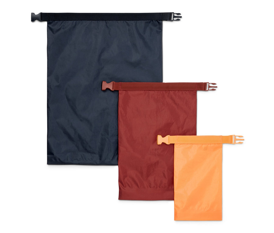 Trzy wodoodporne worki w kolorach niebieskim, brązowym i pomarańczowym.