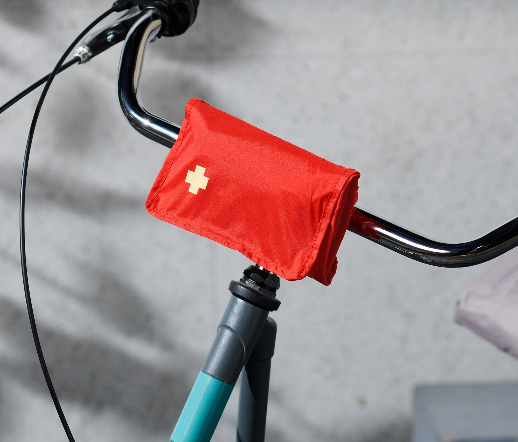 Apteczka pierwszej pomocy na rower przymocowana do kierownicy roweru.