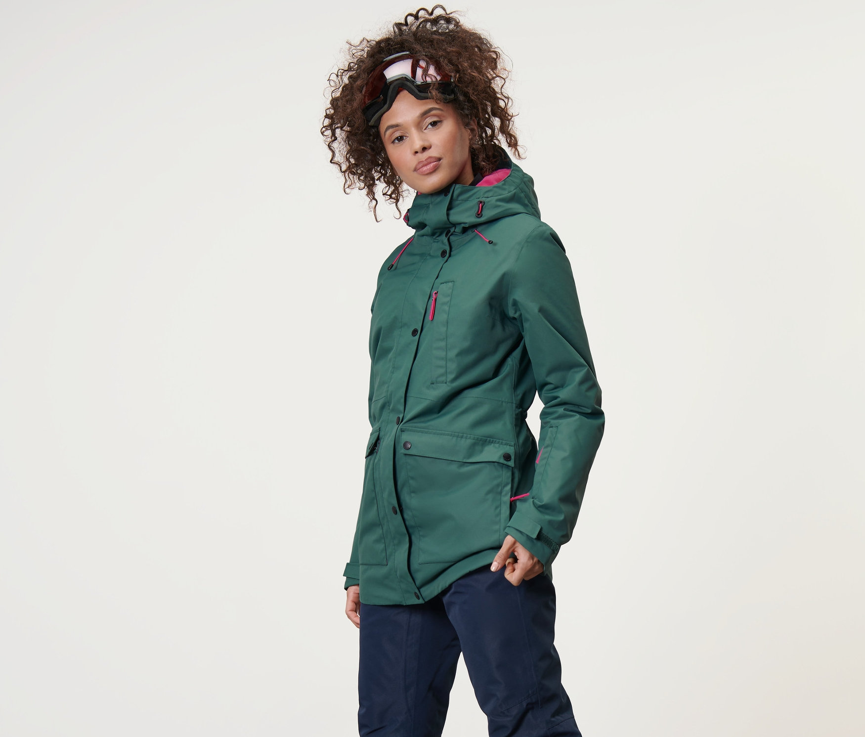 Kobieta ma na sobie kurtkę narciarską i snowbordową oraz spodnie narciarskie.