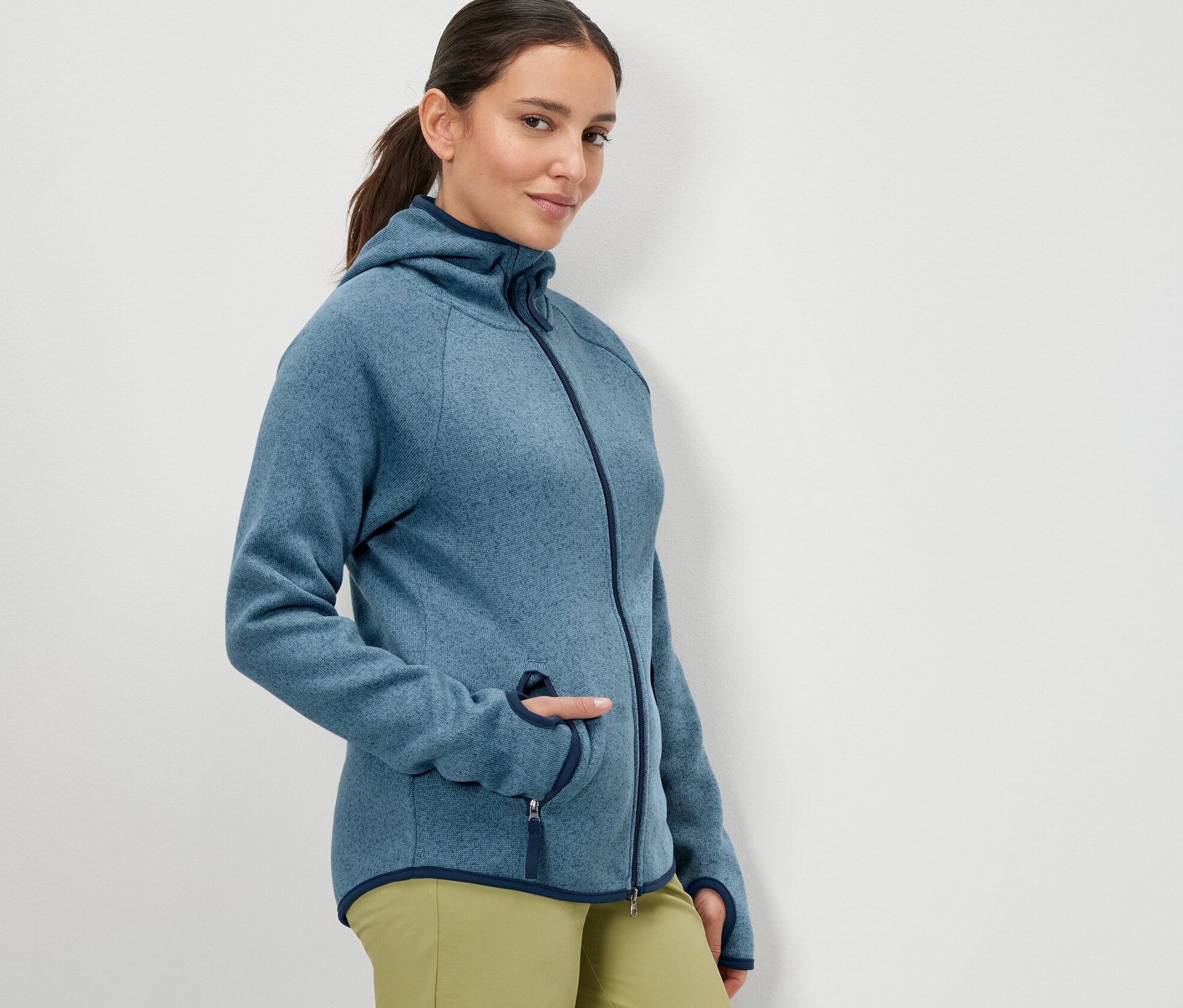 Kobieta pozuje w granatowej, rozpinanej bluzie z dzianiny polarowej.