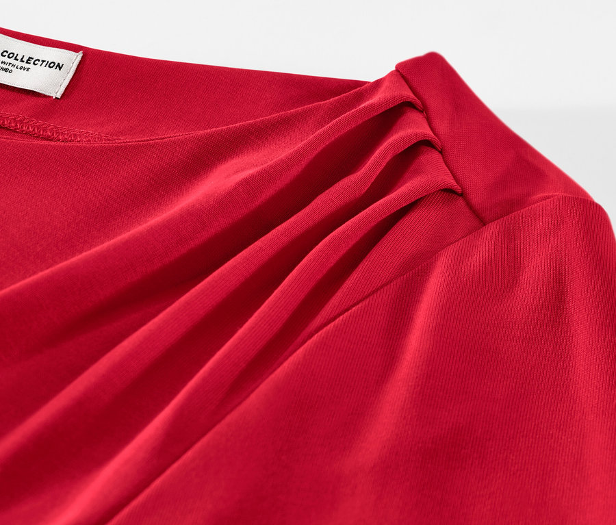 Zbliżenie na czerwoną bluzkę z marszczeniem.