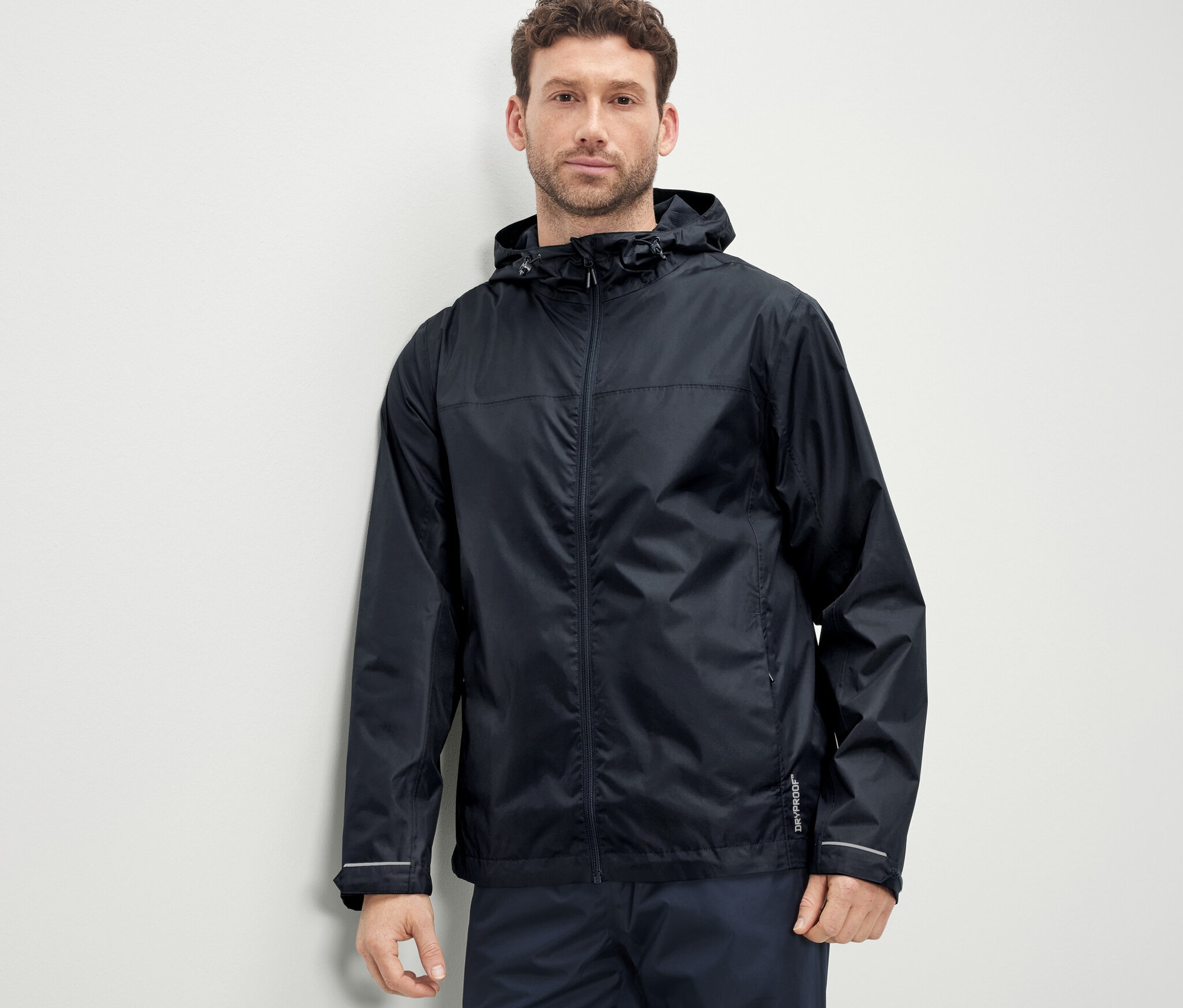 Mężczyzna ma na sobie kurtkę przeciwdeszczową unisex.