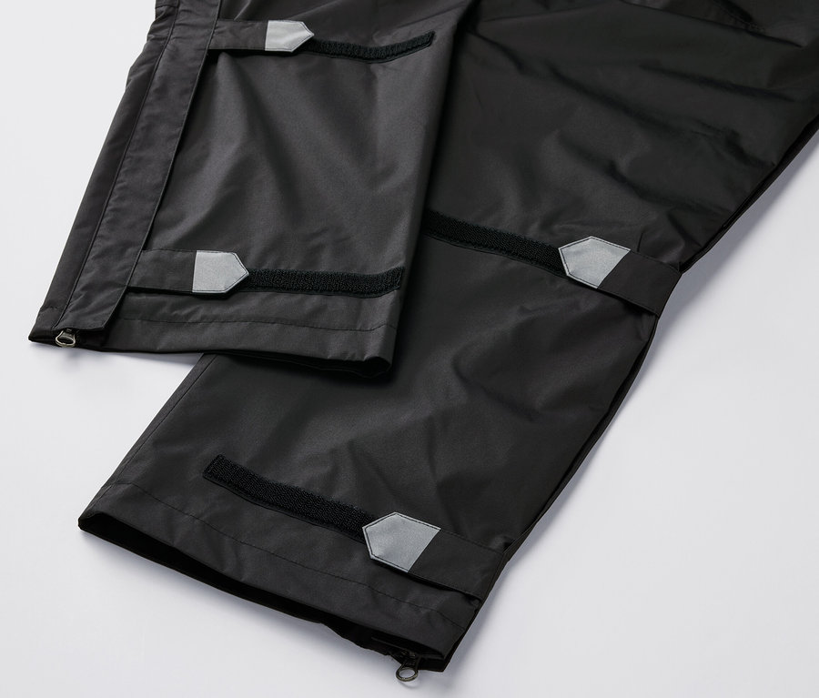 Szczegółowy widok na czarne spodnie przeciwdeszczowe.