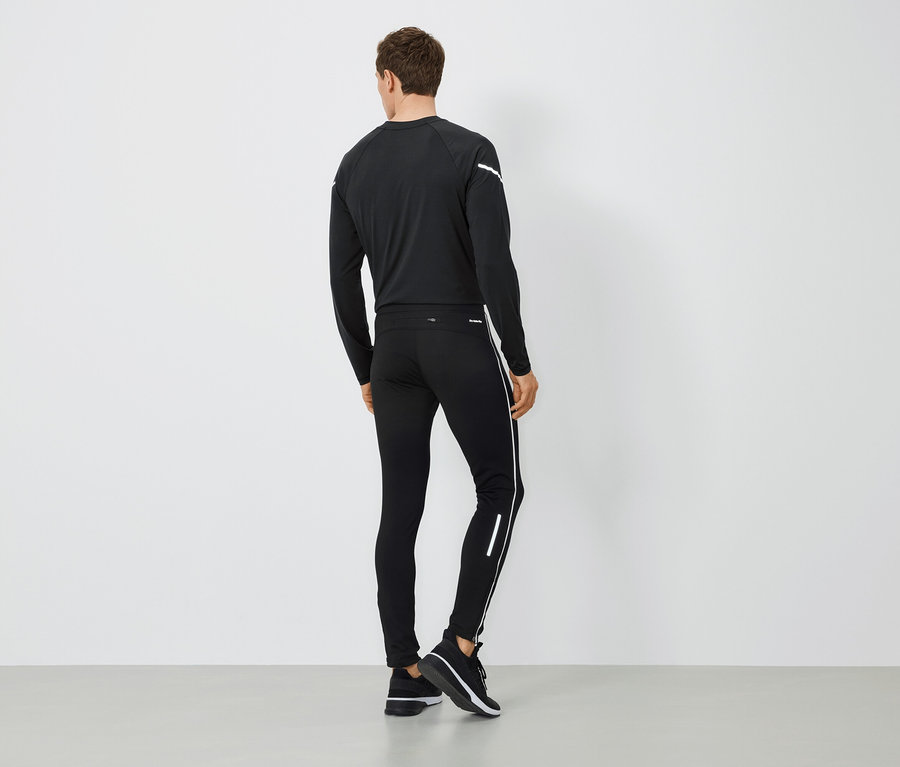 Mężczyzna tyłem do aparatu ubrany w czarną odzież sportową.