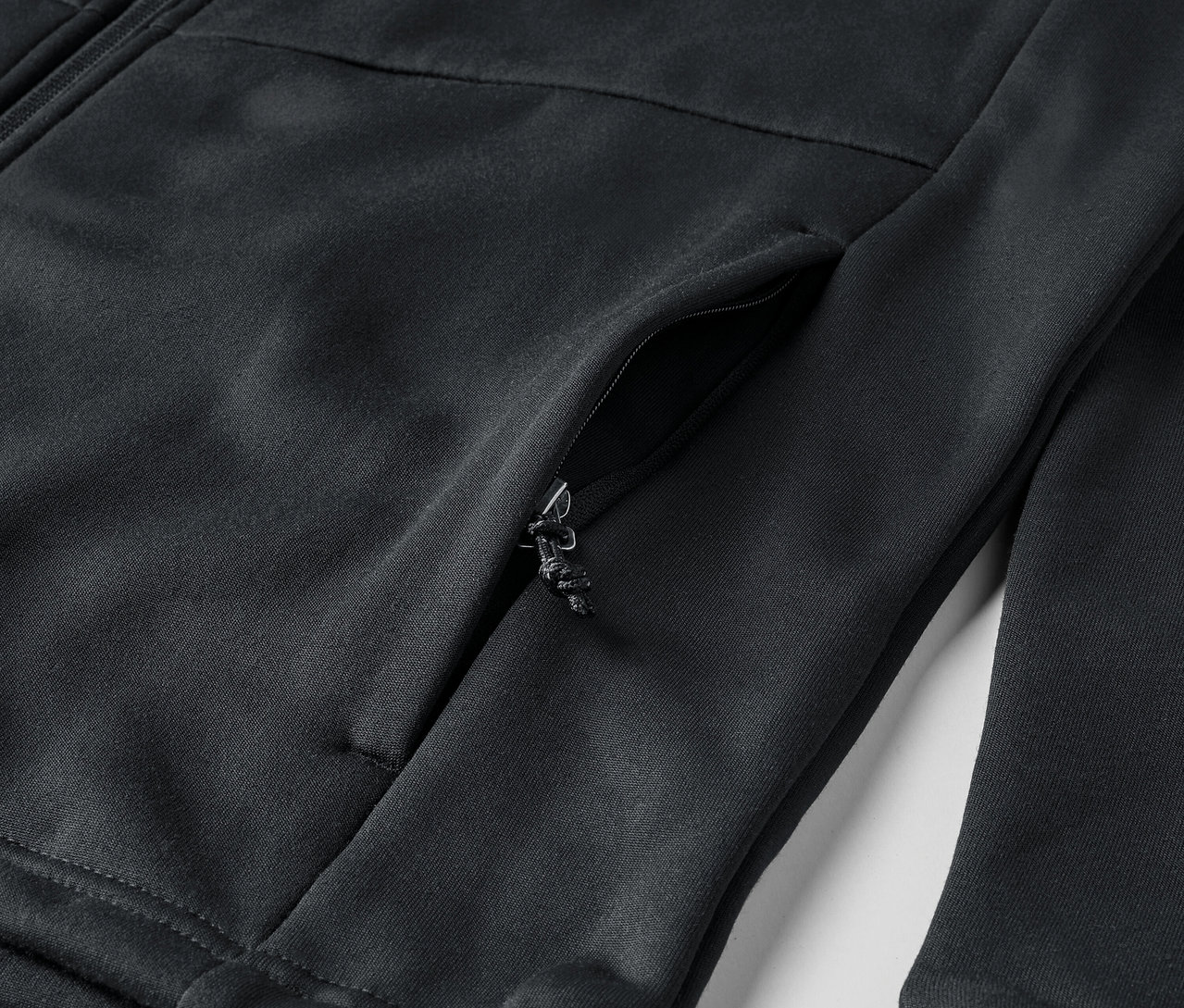 Zbliżenie na czarną bluzę z zamkiem i kieszenią.