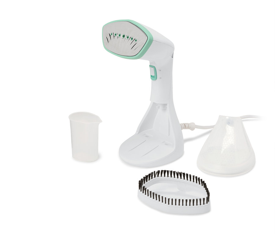 Zestaw białego parowego żelazka ręcznego z miarką, szczotką i zbiornikiem na wodę.