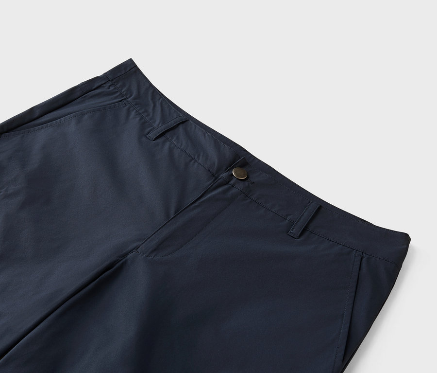 Zbliżenie granatowych spodni zapinanych na guzik.