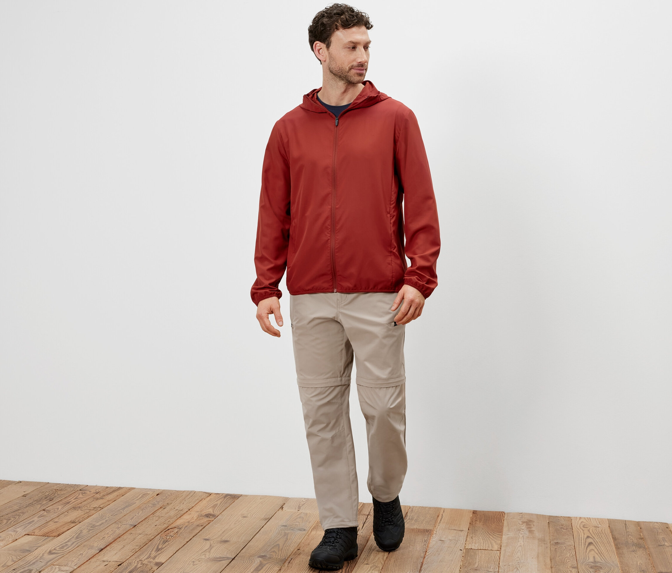 Mężczyzna idzie i ma na sobie kurtkę funkcyjną z możliwością spakowania.