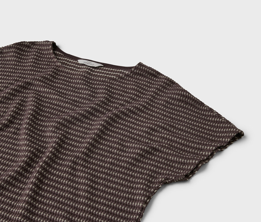 Zbliżenie brązowego T-shirtu z krótkim rękawem i jasnym wzorem w kropki na szarym tle.