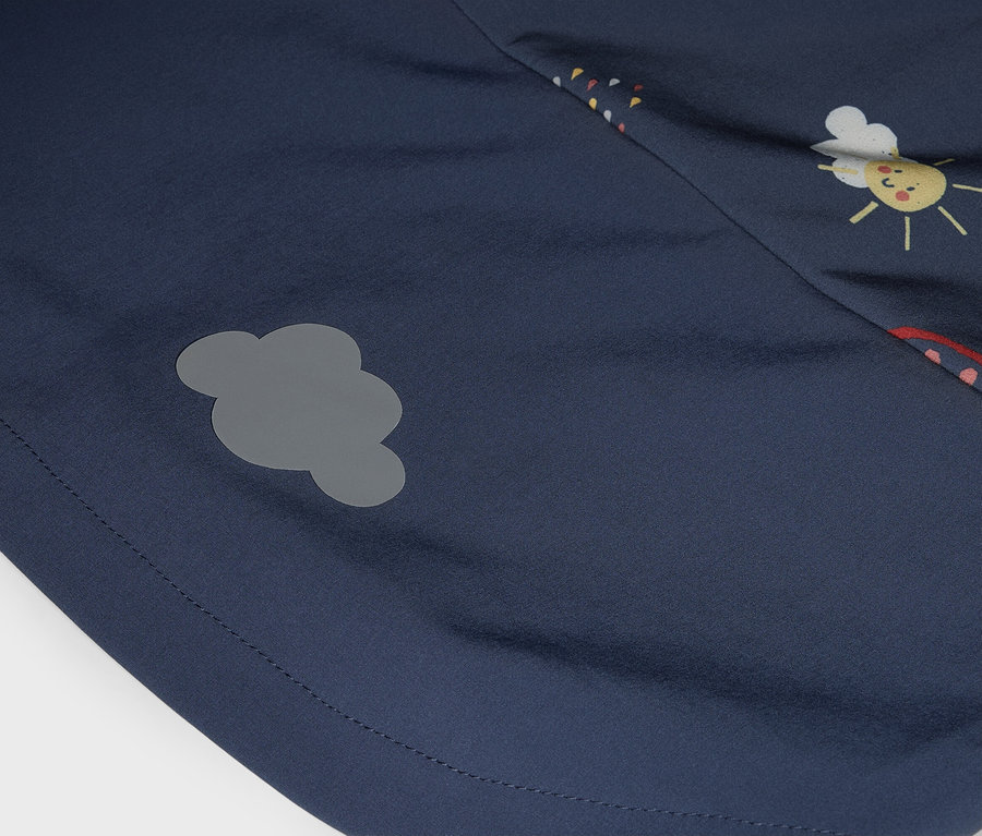 Zbliżenie granatowego materiału z szarym naszywką w kształcie chmury i nadrukiem z buzią słońca.