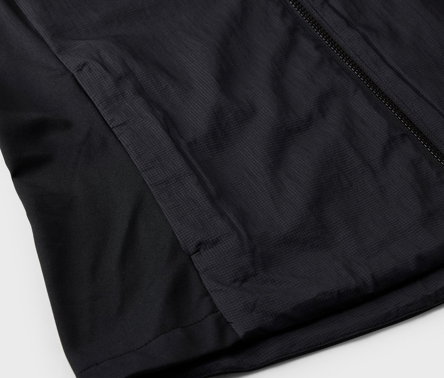 Szczegółowy widok czarnej kurtki z zamkiem błyskawicznym i boczną kieszenią.