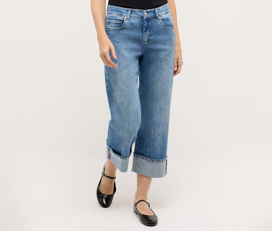 Kobieta ma na sobie dżinsy Angels „Linn Cool” i czarne buty typu Mary Jane.