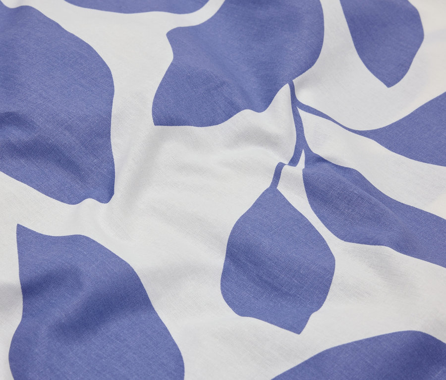 Zbliżenie tkaniny z niebieskim wzorem liści na białym tle.