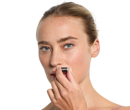 Kobieta używa mini depilatora do twarzy.