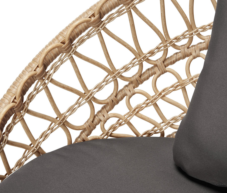 Szczegół stylowej ławki ogrodowej z plecionką polirattanową i szarą poduszką.