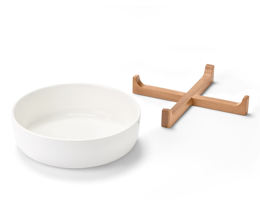 Porcelanowa forma do zapiekania obok drewnianego stojaka.