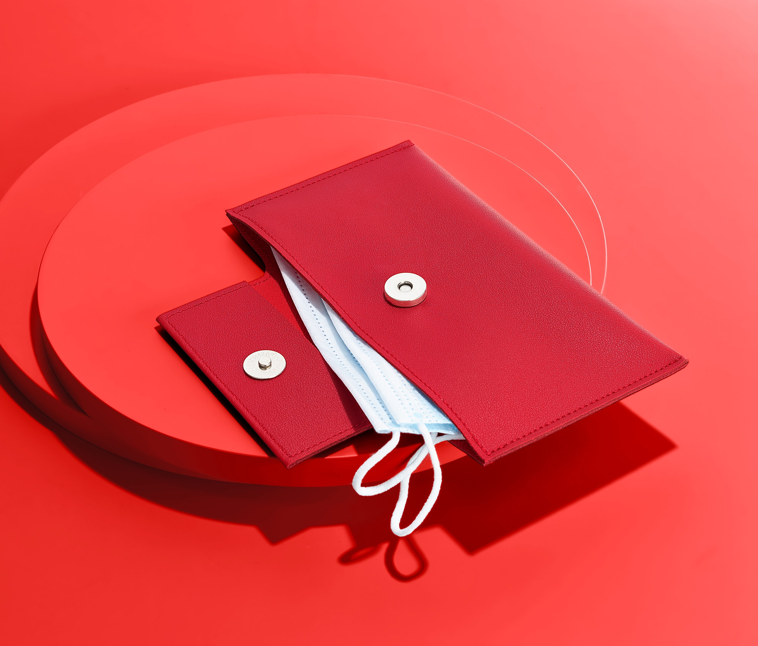 Czerwone etui na maseczki ochronne na czerwonym tle.