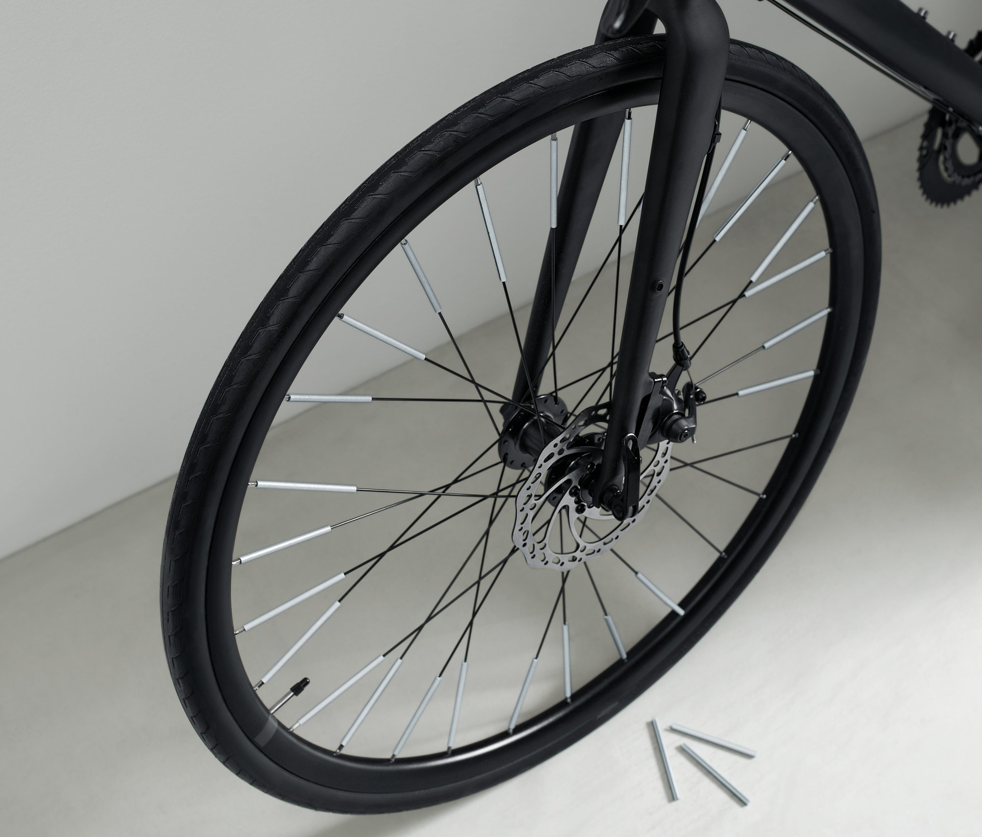 Zbliżenie na czarny rower z 36 odblaskami na szprychach.
