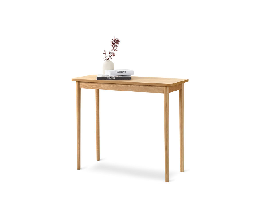 Na jasnym drewnianym stole konsolowym leżą dwie książki i wazon z kwiatami.