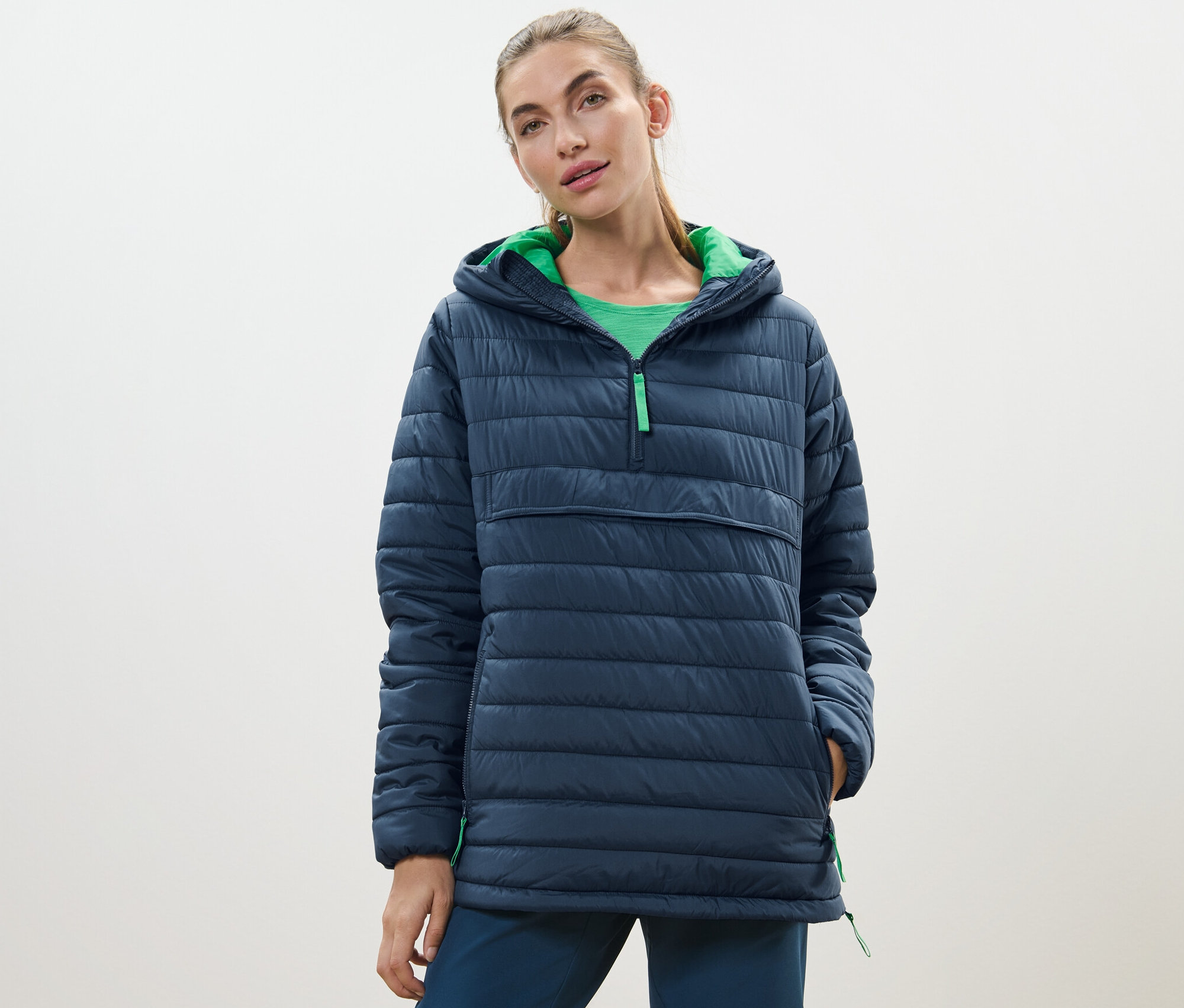 Kobieta ma na sobie pikowaną kurtkę z kapturem.