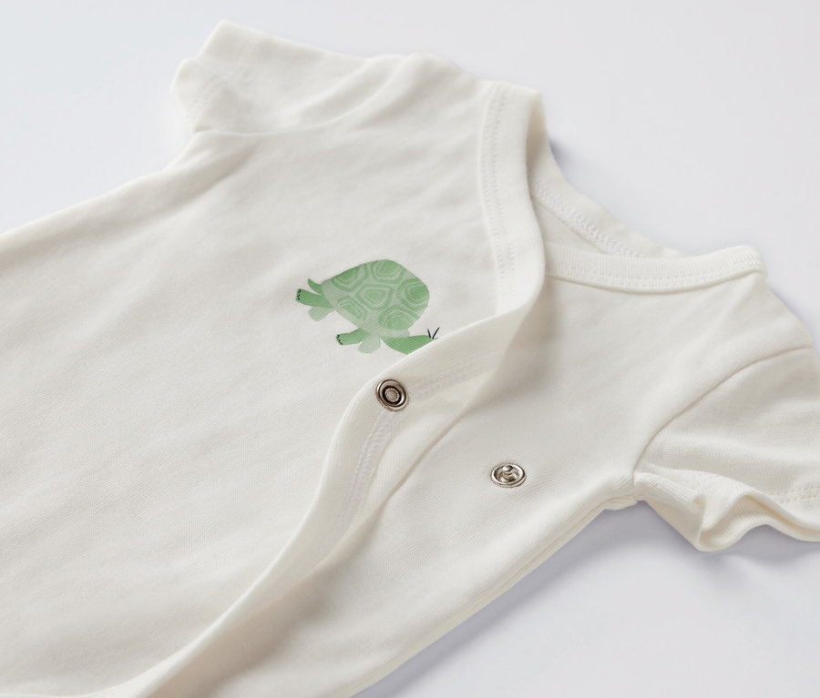 Zbliżenie na białe body z krótkim rękawem i motywem żółwia.