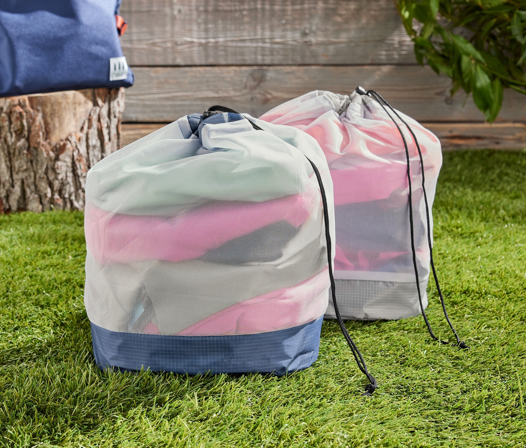 Dwa worki z siatki na trawie, w tle plecak.
