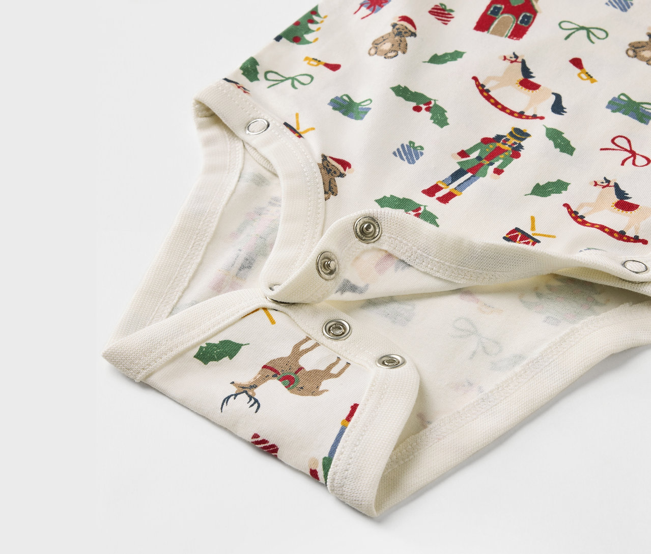 Detal dziecięcego body z świątecznym nadrukiem.