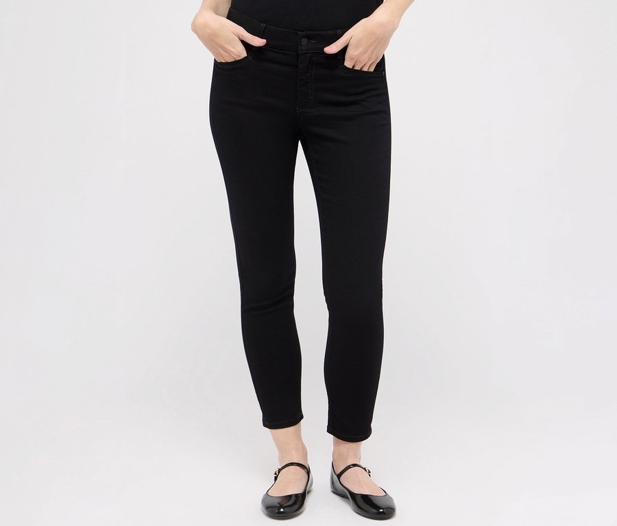 Kobieta ma na sobie czarne dżinsy Angels „Ornella sporty” i czarne buty.