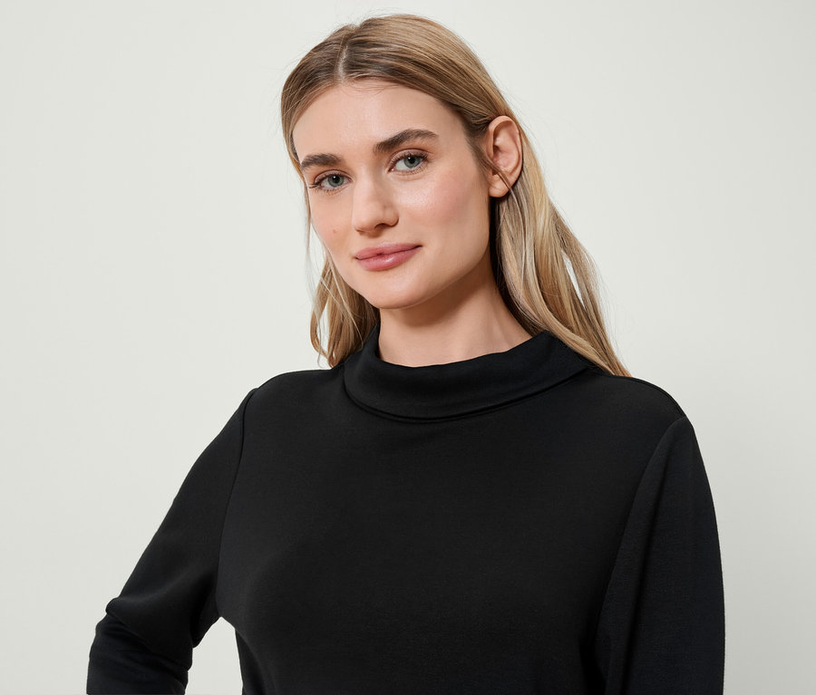 Portret blondynki w czarnym golfie.