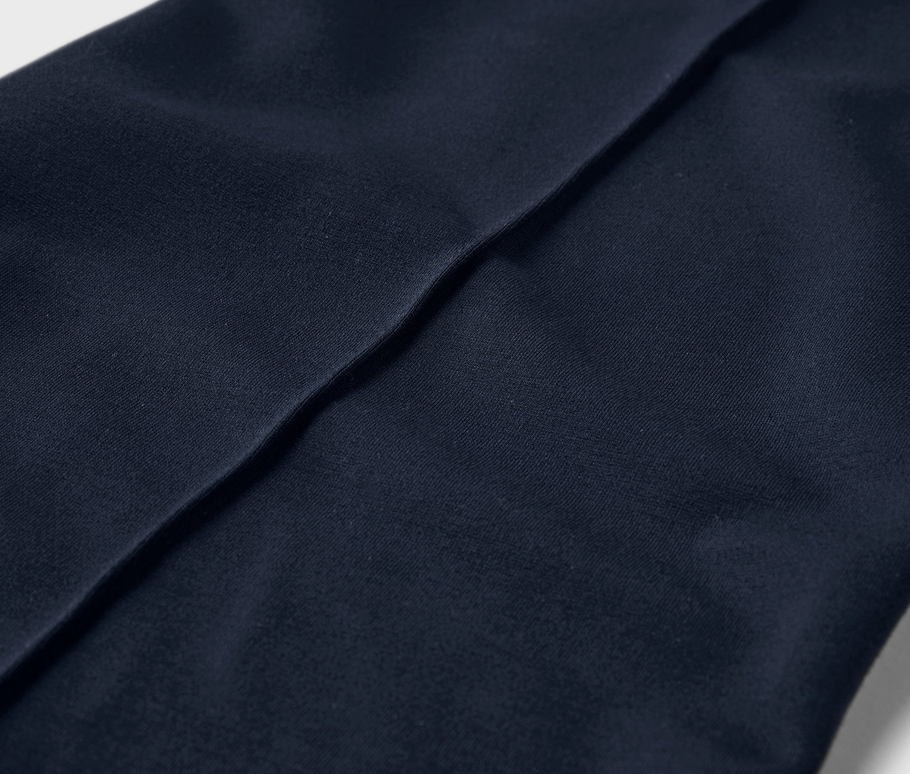 Szczegółowe ujęcie dżersejowych spodni z przeszyciem.