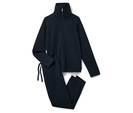 Na białym tle leży granatowy dres składający się z rozpinanej bluzy i spodni.