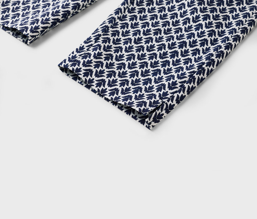 Zbliżenie nogawek spodni z niebiesko-białym wzorem w liście.