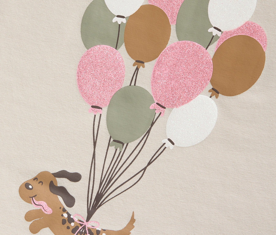 Grafika przedstawia kreskówkowego psa wiszącego na balonie.