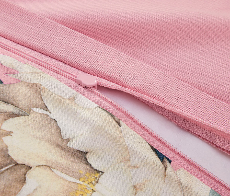 Zbliżenie na częściowo otwarty zamek błyskawiczny na różowej poszewce na poduszkę w kwiaty.