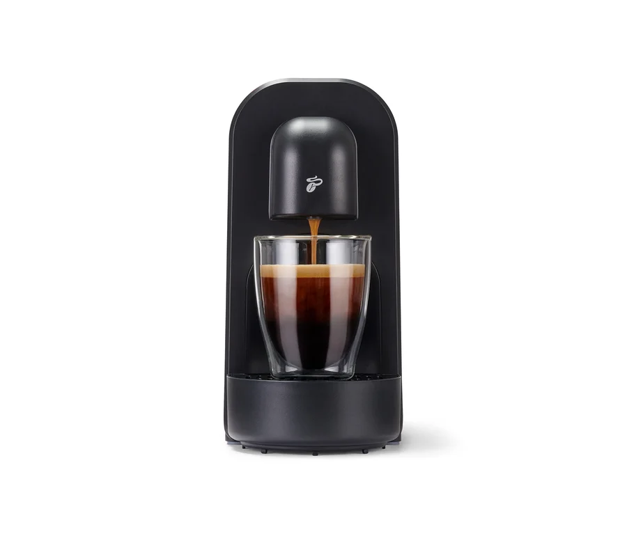 Espresso wlewa się z czarnego Cafissimo now do szklanki.