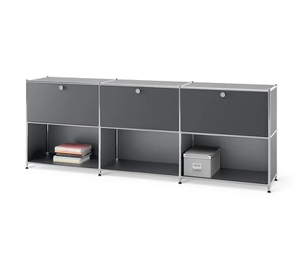 Szara metalowa szafka typu sideboard »CN3« z 3 przesuwnymi przegródkami z klapami. Na dole leżą książki i szare pudełko.
