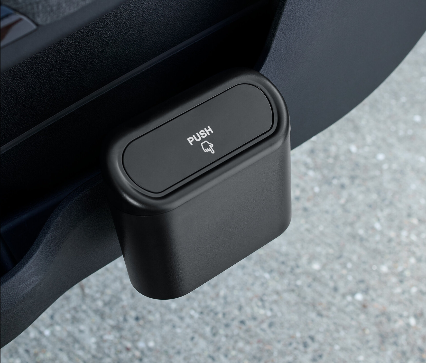 Czarny pojemnik na śmieci do samochodu umieszczony w drzwiach samochodu.